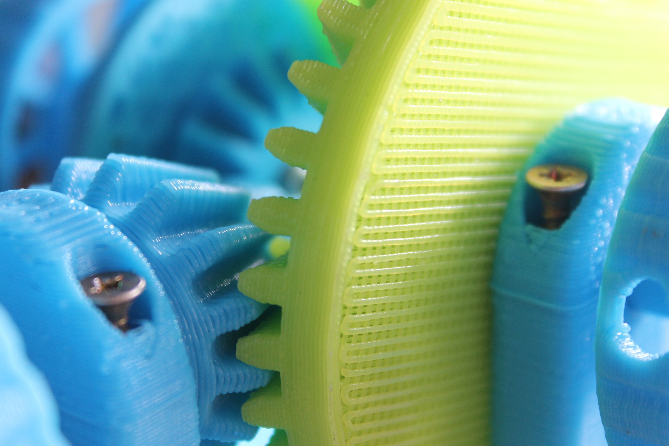 Close-up of interlocking 3D-printed gear mechanisms showing FDM layer detail before finishing