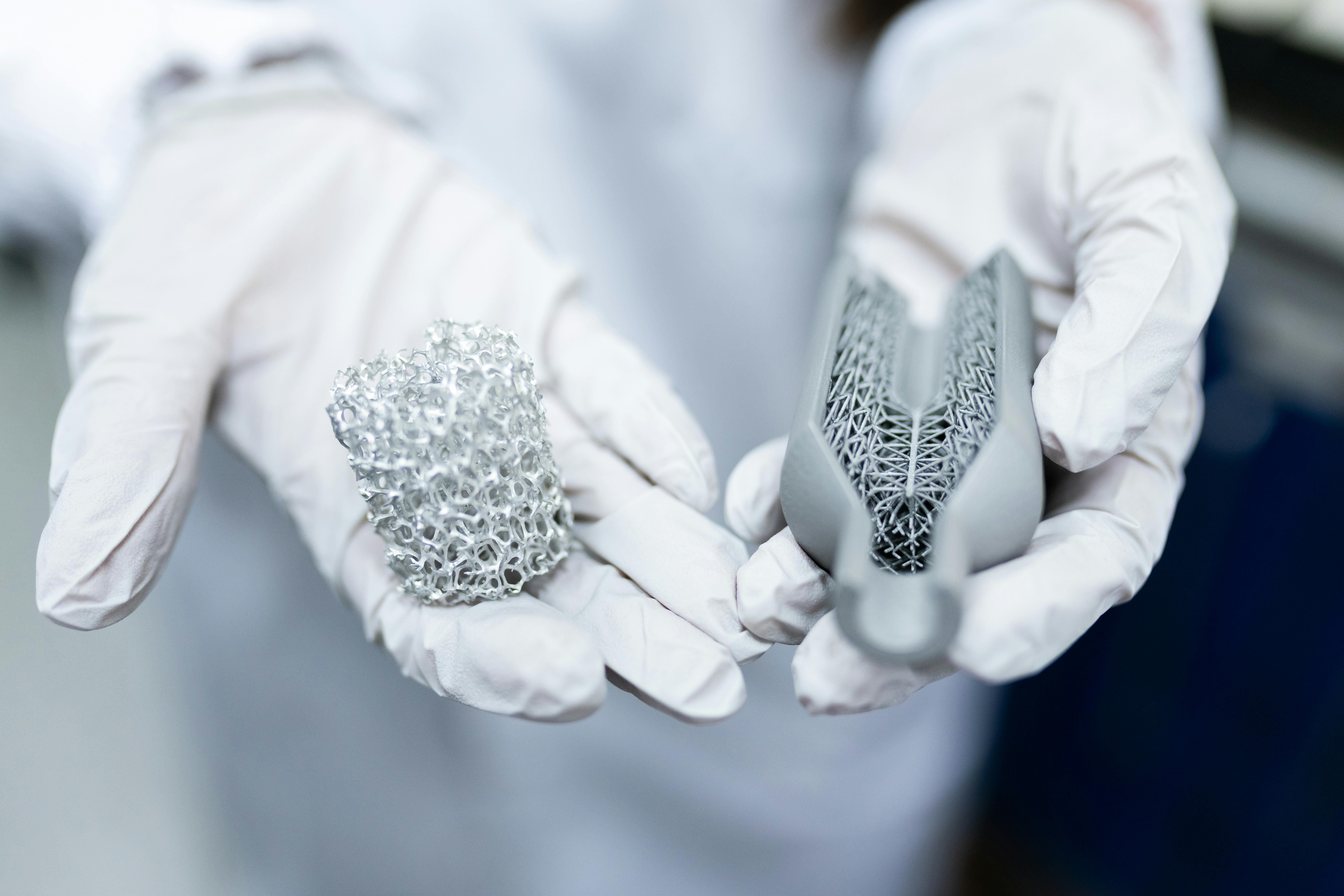 Precision 3D-printed structural mesh models held by gloved hands, illustrating the quality and craft behind Cascade Forge design services
